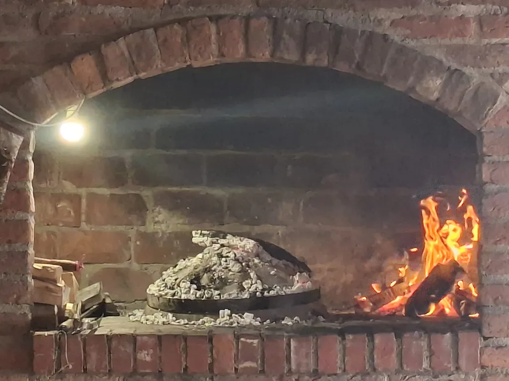 Vatra na ognjištu pod ciglenim lukom